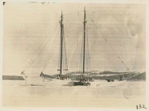 Image of Bowdoin in winter quarters with snowmobile alongside.`